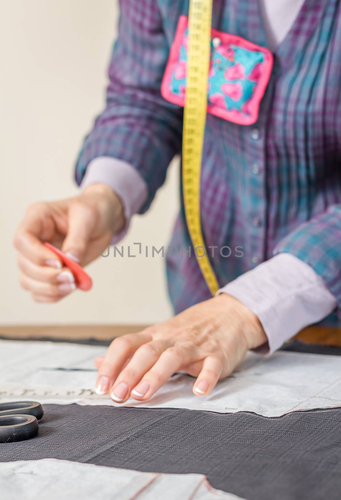 Woman dressmaker design tailor pattern for a suit on the table