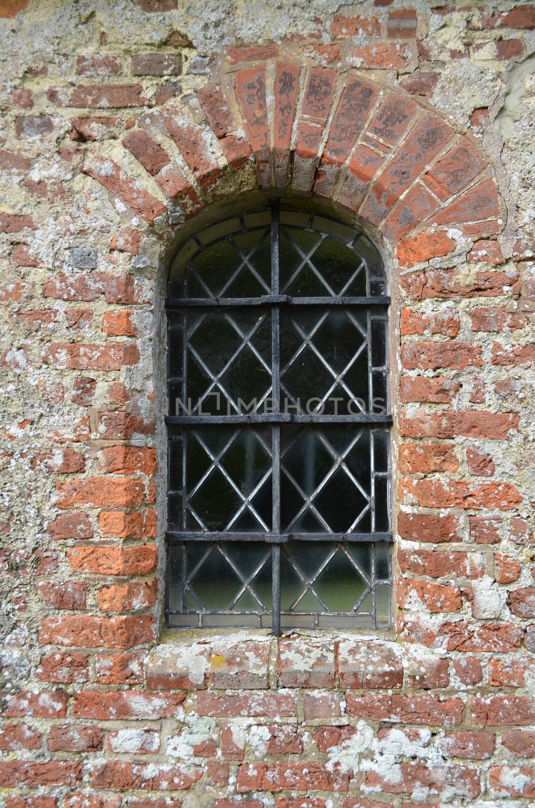 Brick built window, 1600 period with its patterned leaded glass.Image taken from St Peters church in Twineham,Sussex,England.