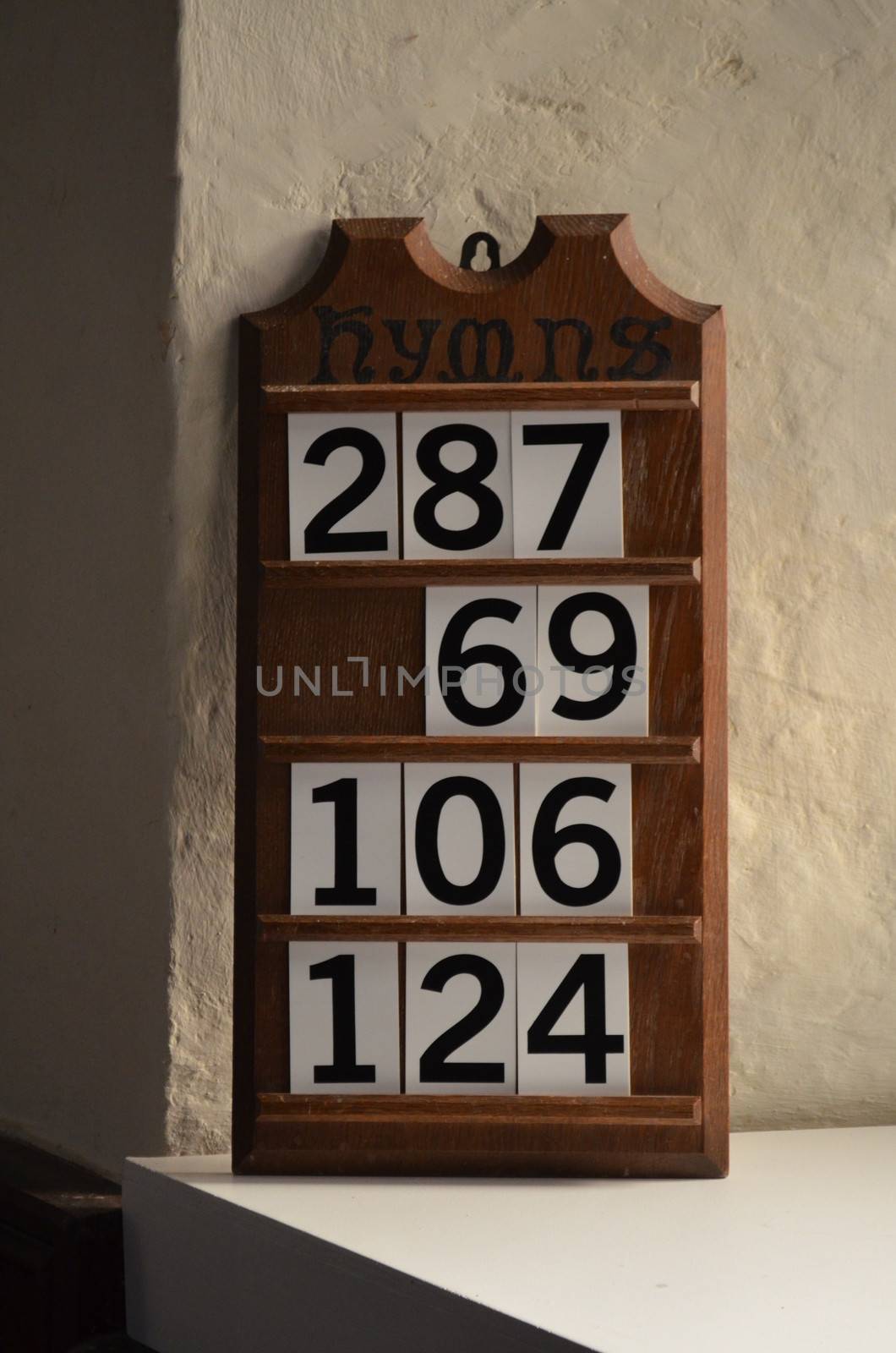 A carved wooden hymn numbers board in a Parish church in England.