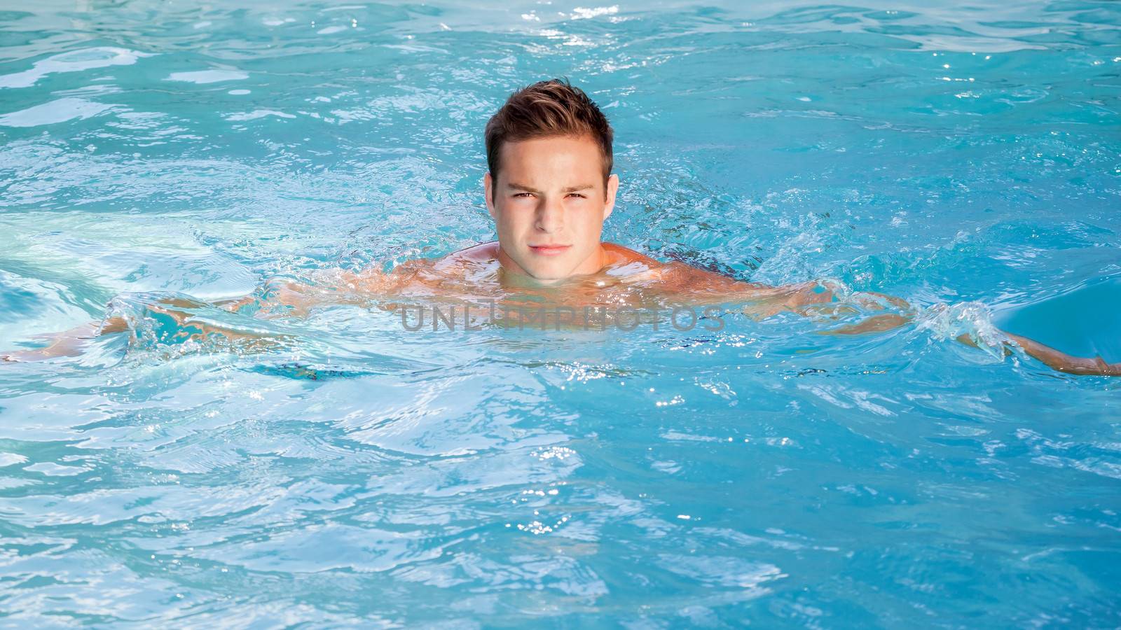 An image of a beautiful man swimming in the pool