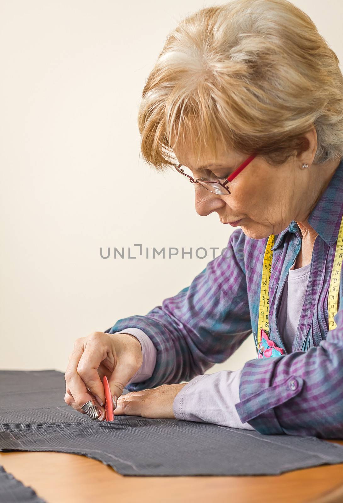 Woman dressmaker design tailor pattern for a suit on the table