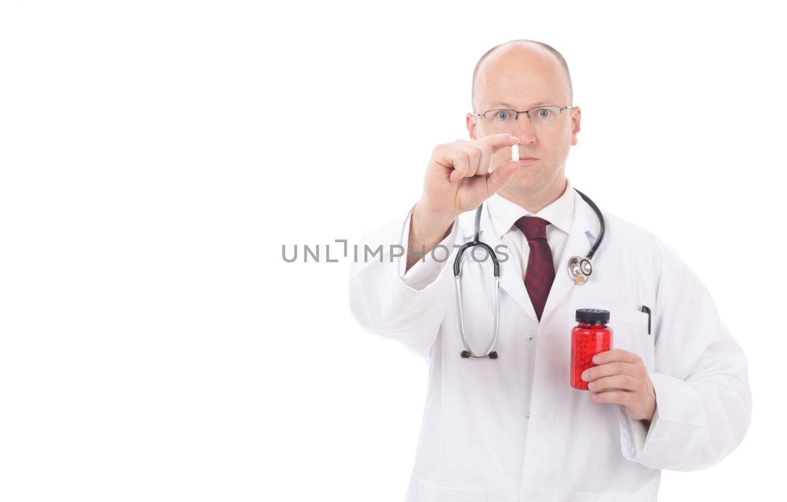 Doctor holding up a pill for administering isolated on white background