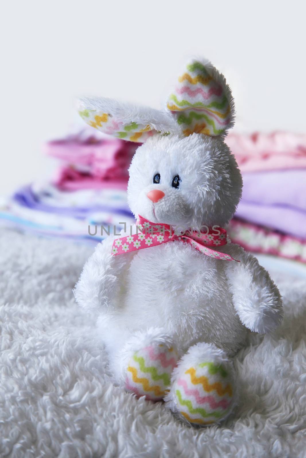 Toy on the background of the heap of children's clothing for the newborn