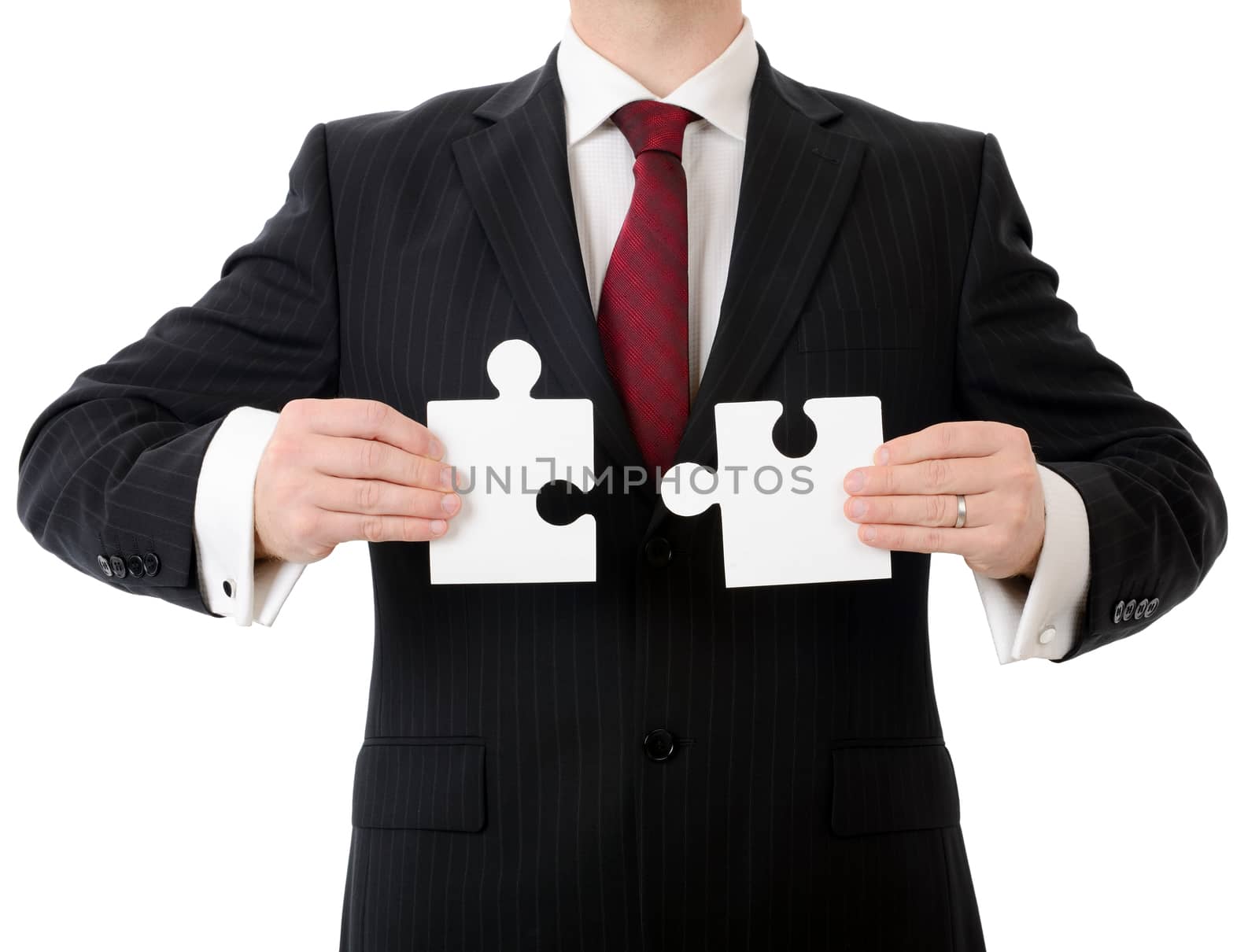 businessman putting together the piaces of a puzzle isolated on a white background