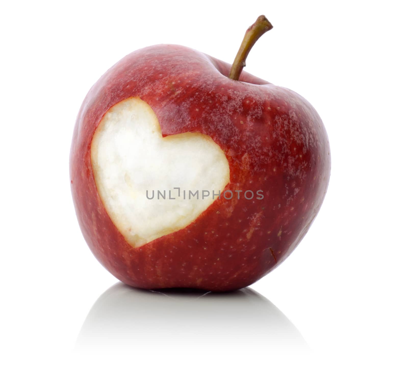 concept for loving healthy food, an apple with a heart symbol carved into it isolated on a white background