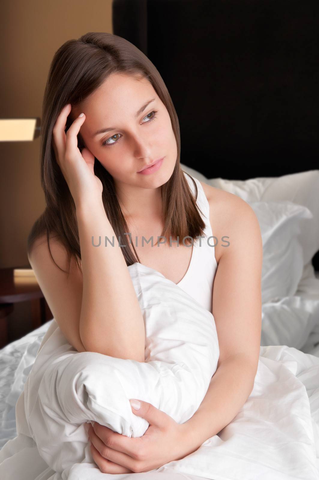 Woman sitting on a bed, waking up