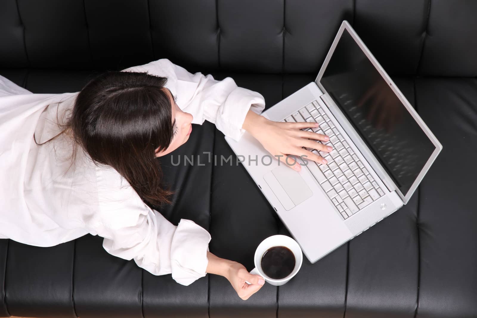 A young woman surfing on the Internet with a Laptop.  