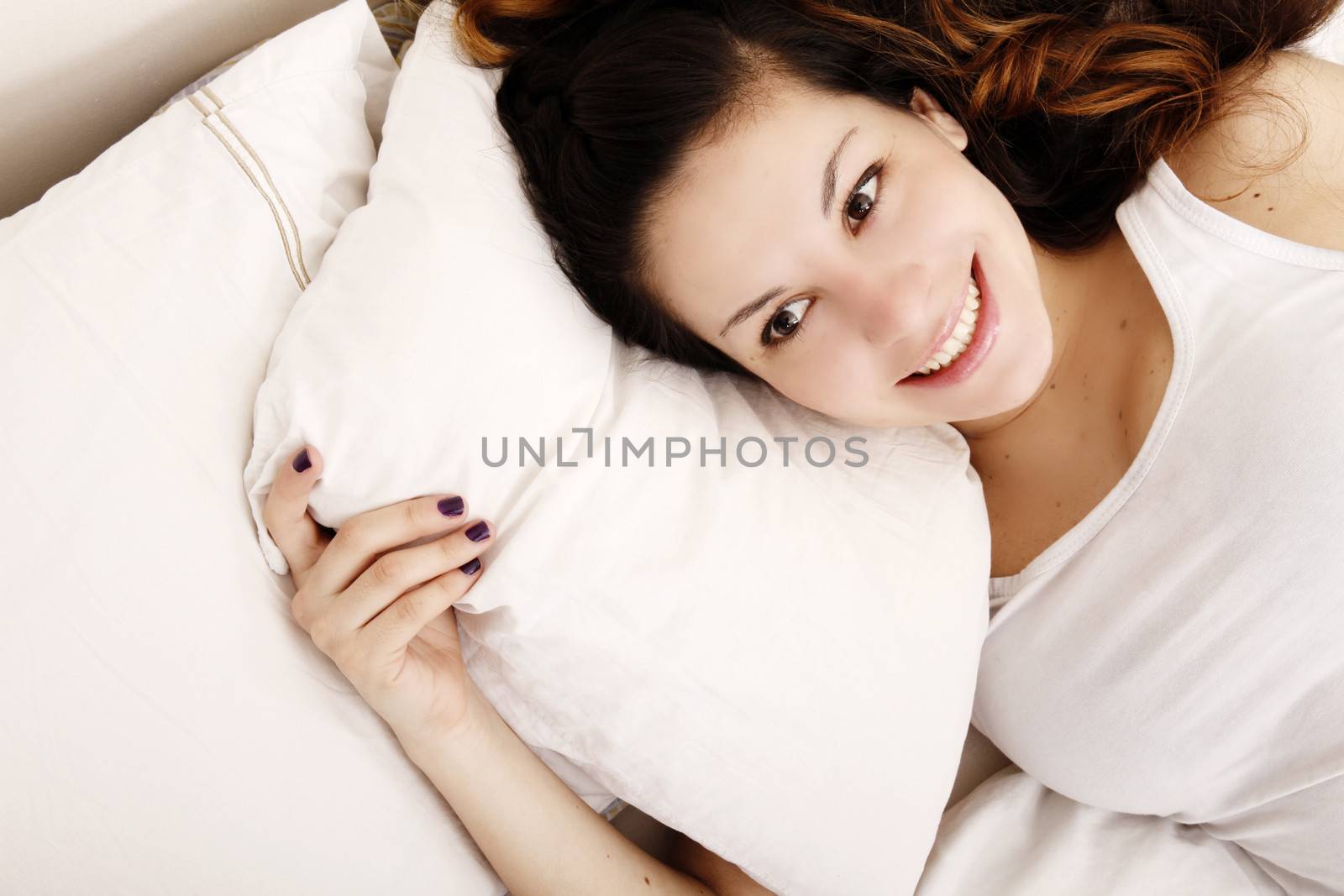 A young adult Woman relaxing on the Bed.