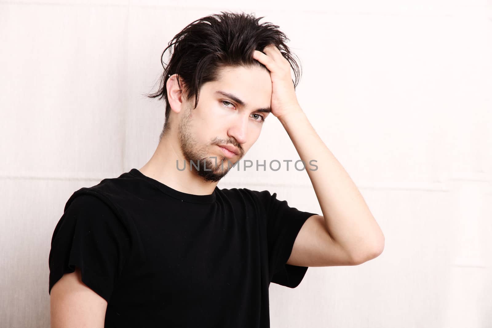 A young hispanic man standing and looking at the camera.