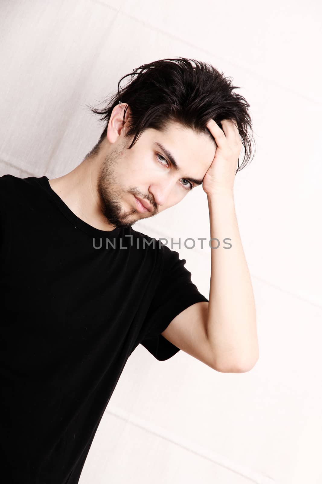 A young hispanic man standing and looking at the camera.