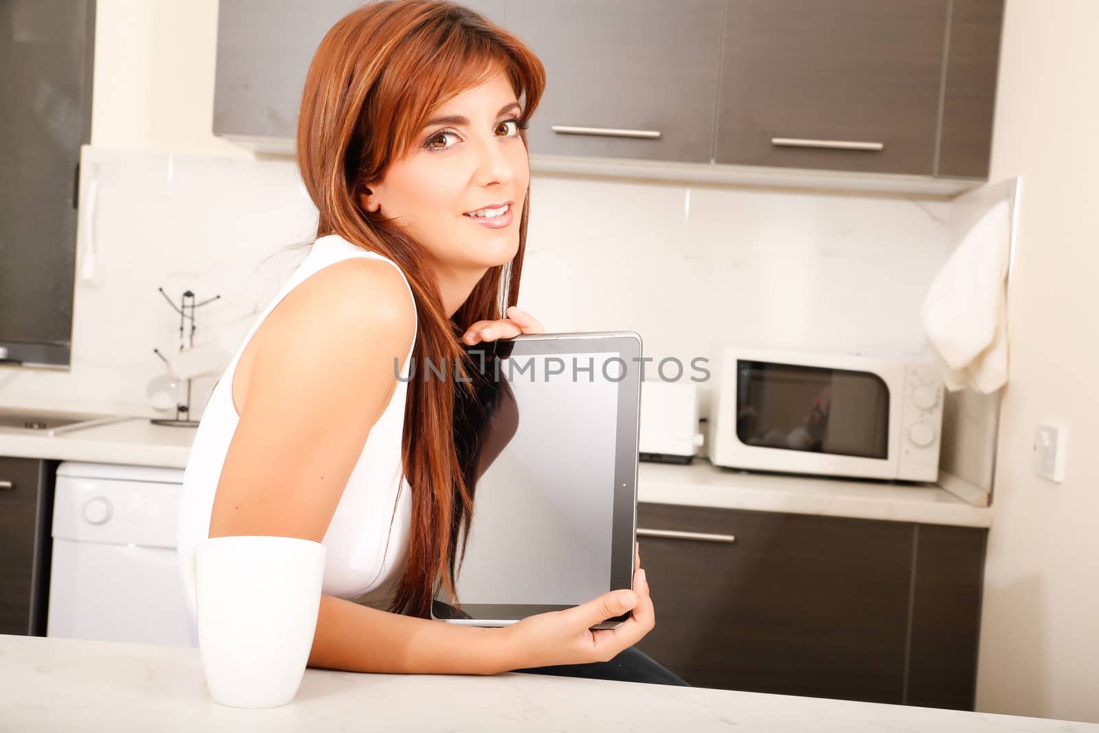 Young woman with a Tablet PC in the Kitchen	 by Spectral