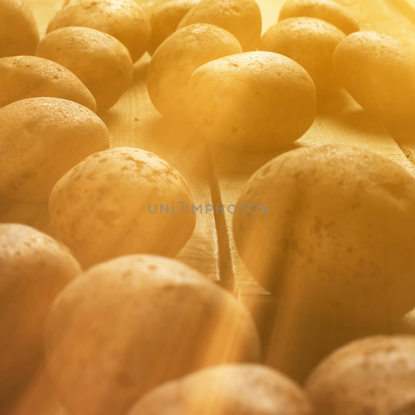 Rustic fresh unpeeled potatoes on a wooden desks