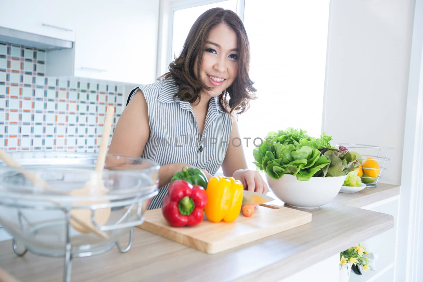 Portrait of beautiful relaxed young woman standing at the kitchen counter
