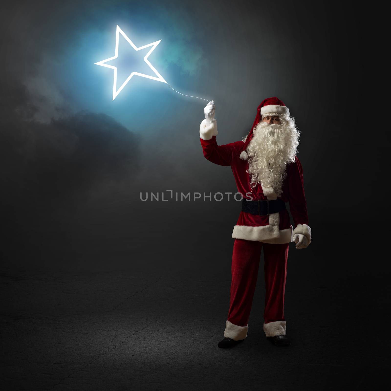 Santa Claus is holding a shining star sign on a string