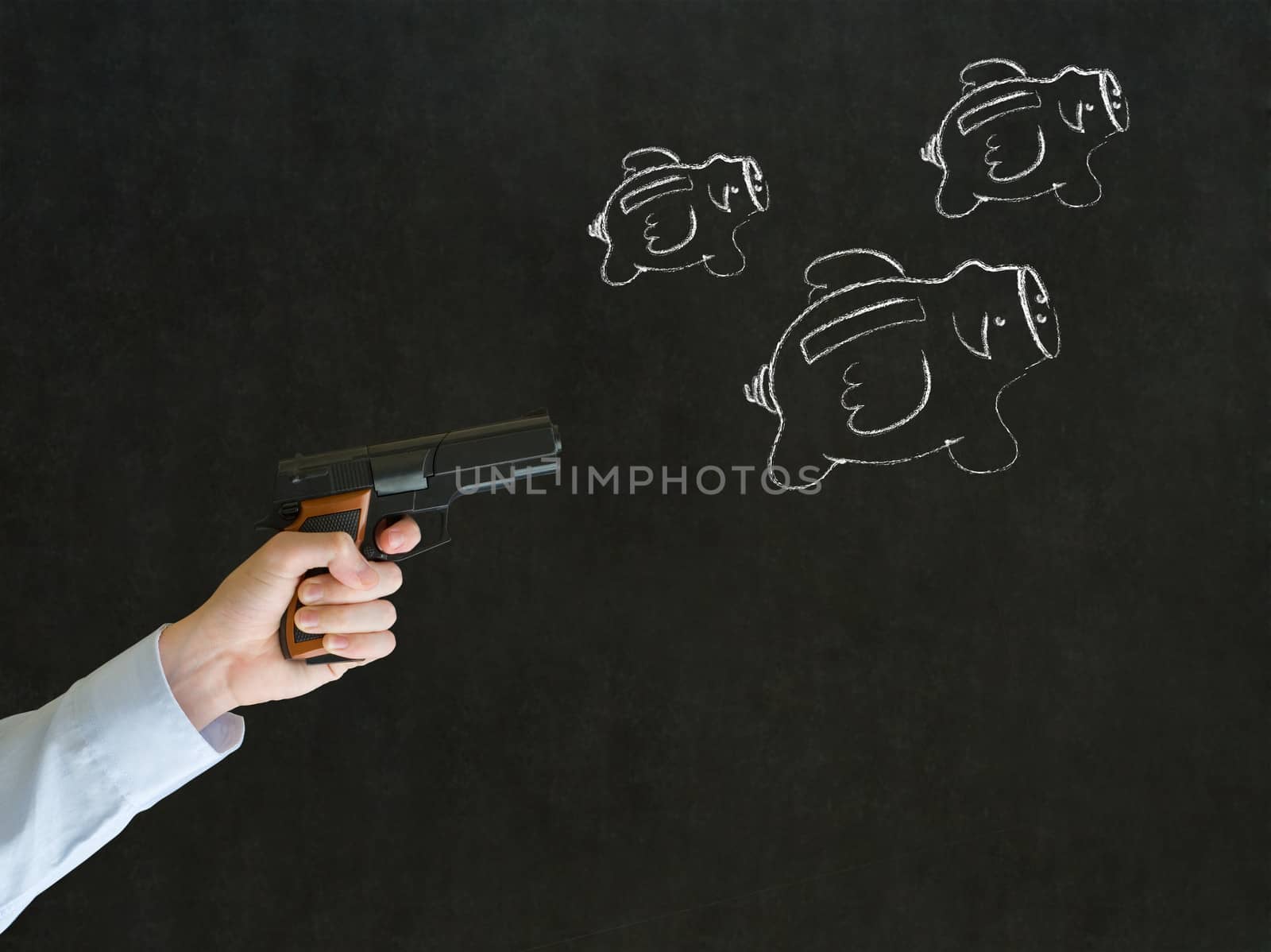Businessman shooting gun at flying money piggy banks in chalk on blackboard background by alistaircotton