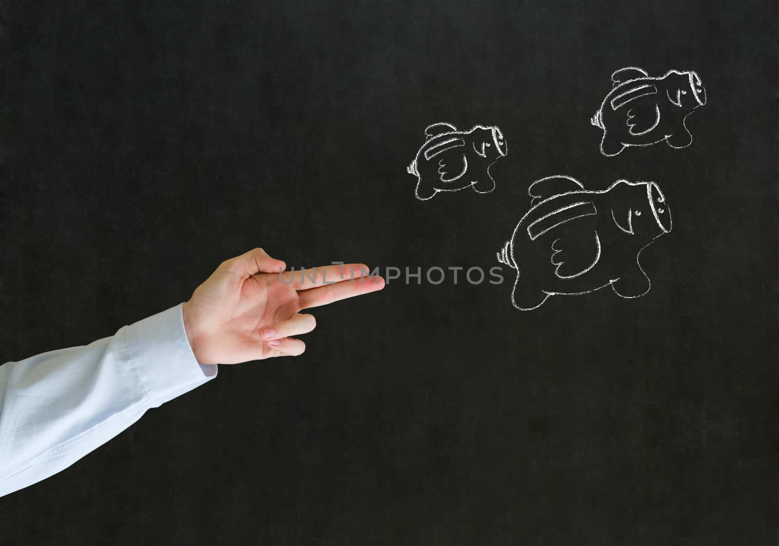 Businessman shooting hand gun at flying money piggy banks in chalk on blackboard background by alistaircotton