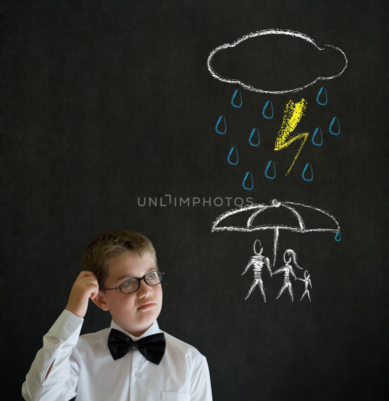 Thinking boy dressed up as business man thinking about protecting family from natural disaster on blackboard background