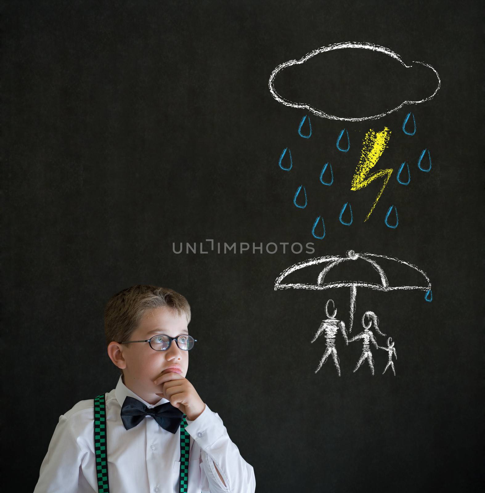 Thinking boy dressed up as business man thinking about protecting family from natural disaster on blackboard background