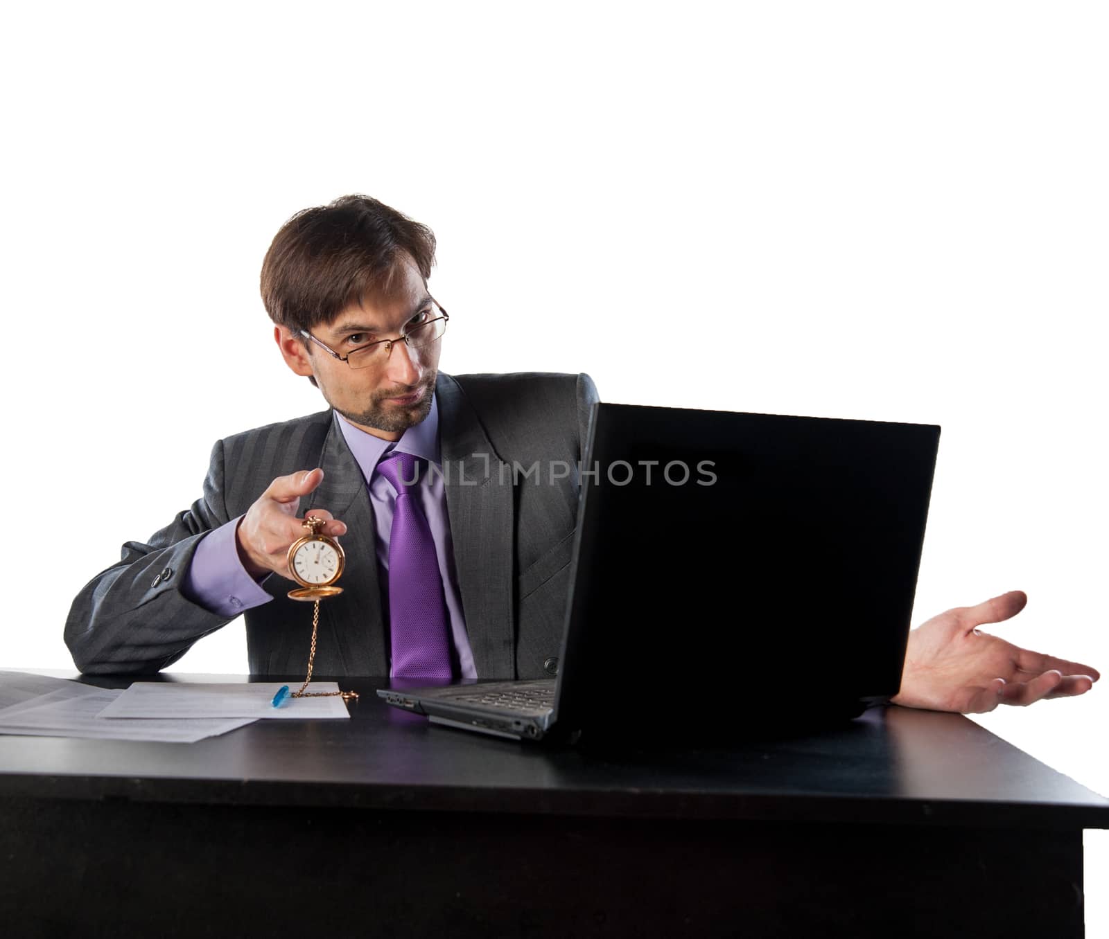 businessman in glasses behind a desk in an office with a clock in his hands