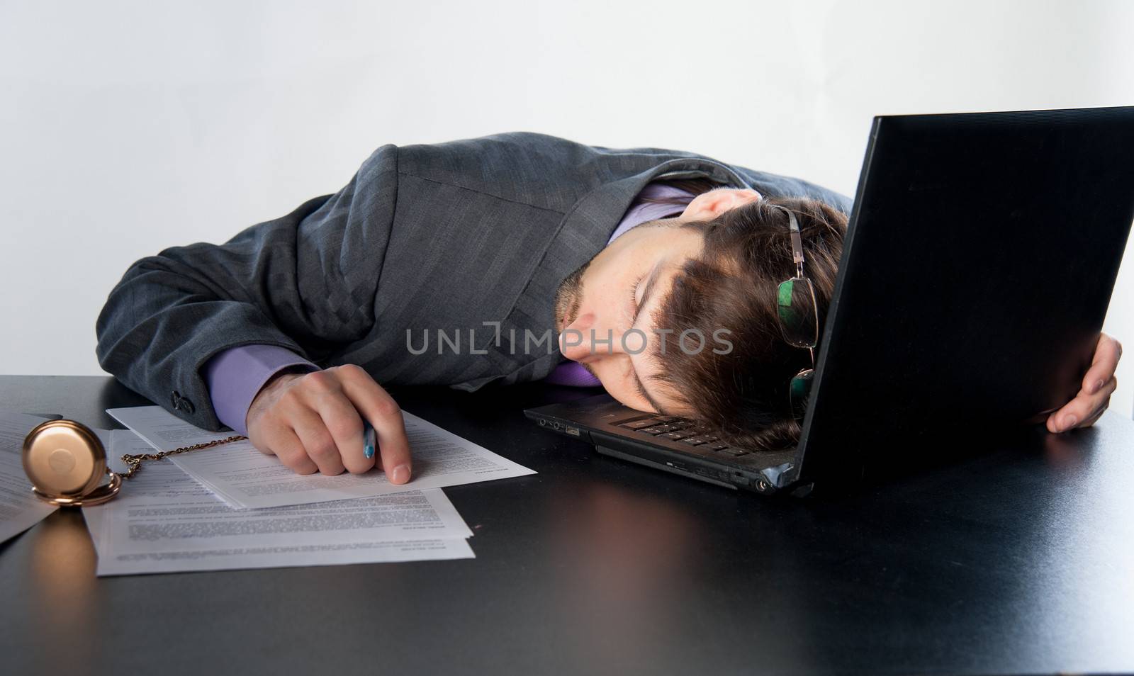 man asleep on a laptop in the workplace
