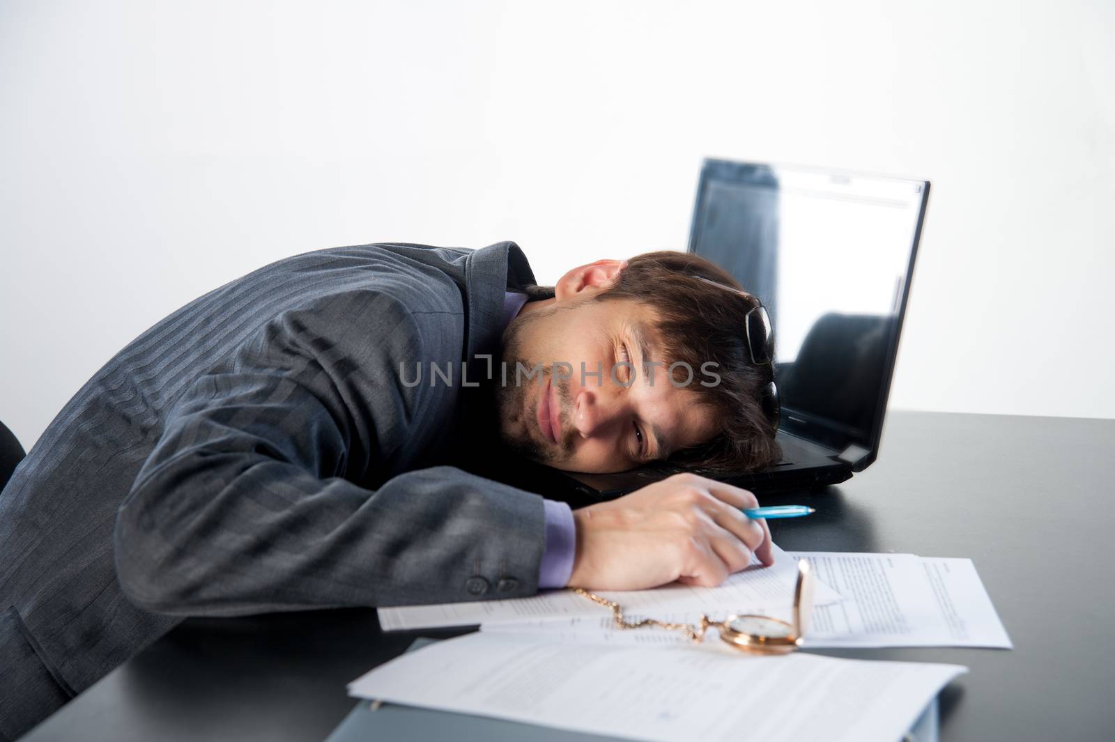 man asleep on a laptop in the workplace