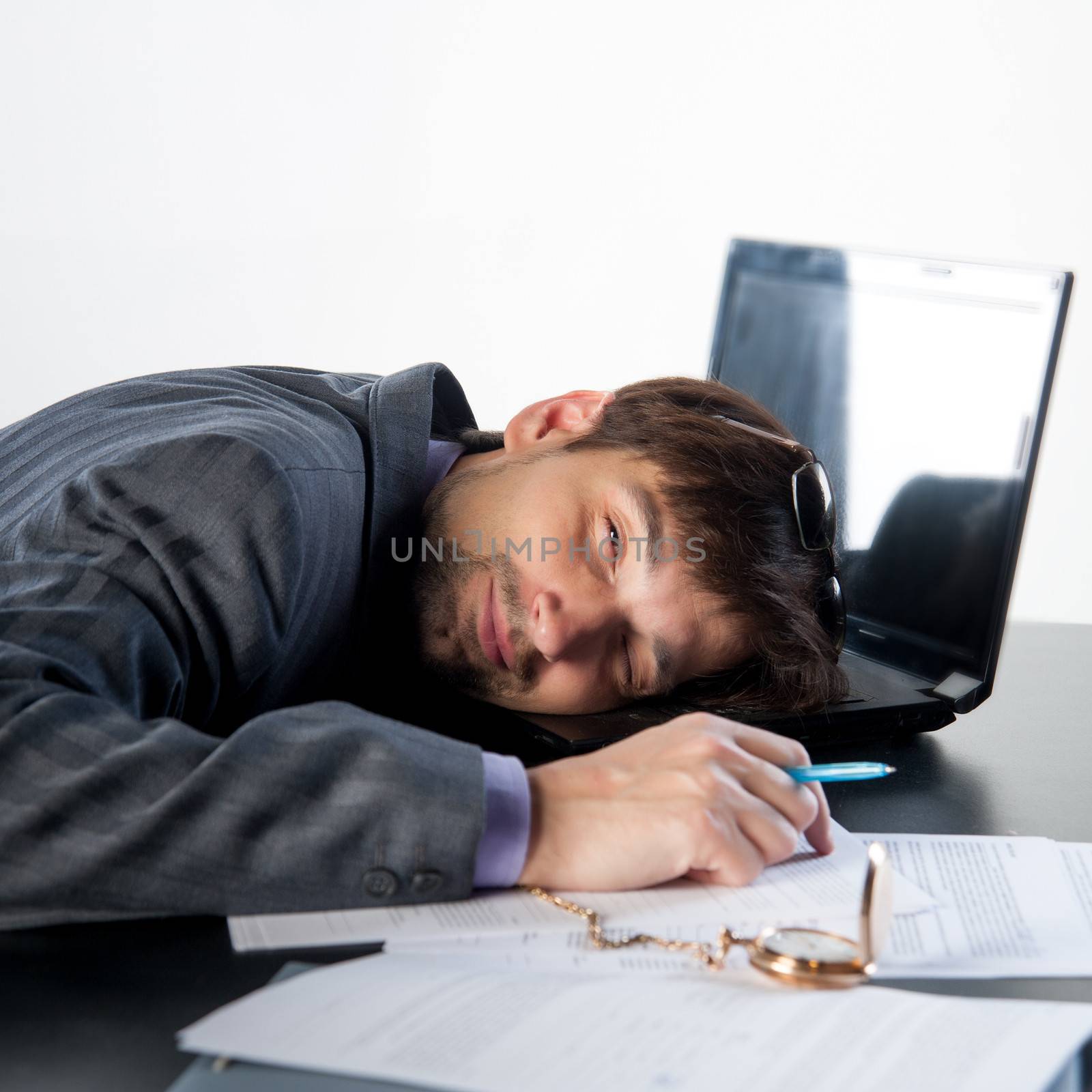 man asleep on a laptop in the workplace