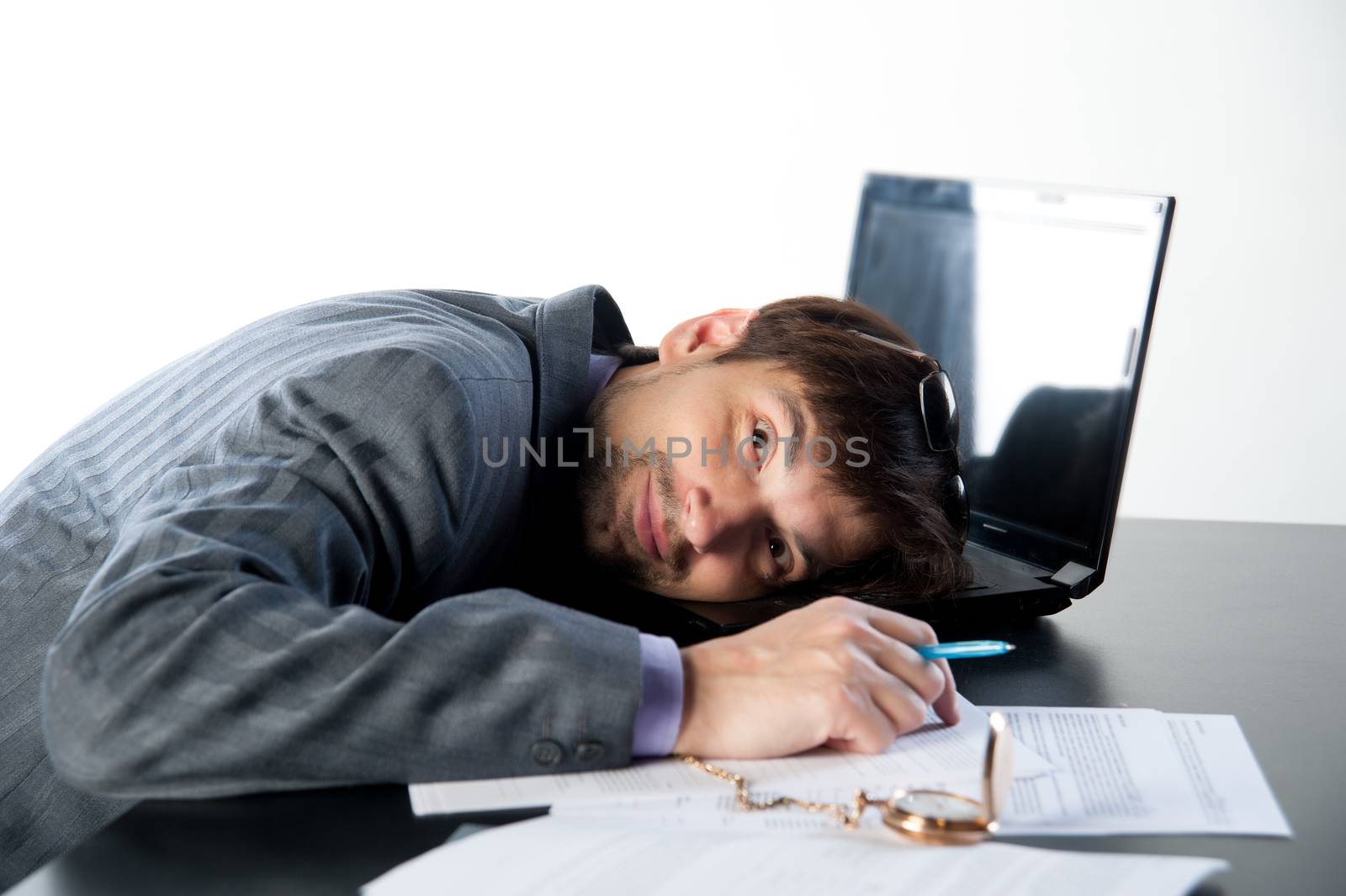 man asleep on a laptop in the workplace