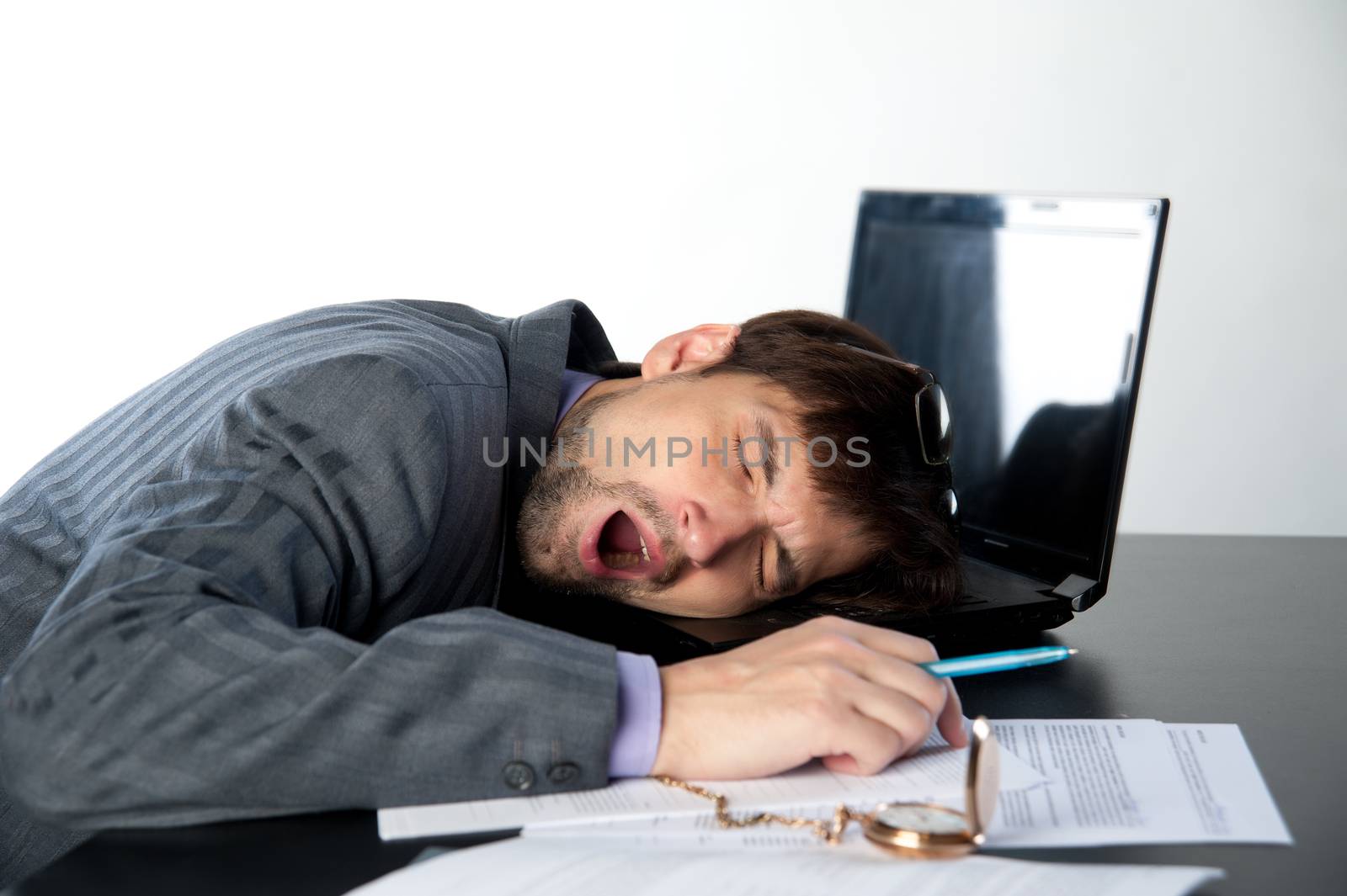 man asleep on a laptop in the workplace