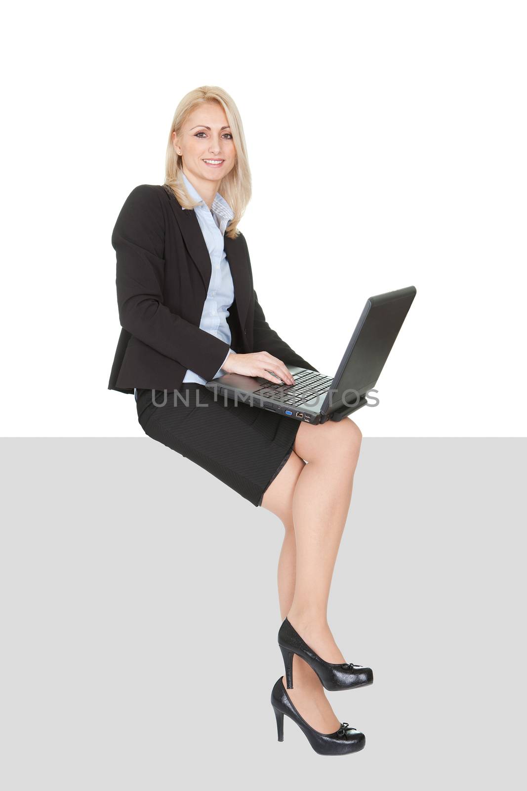 Businesswoman sitting on copyspace. Isolated on white