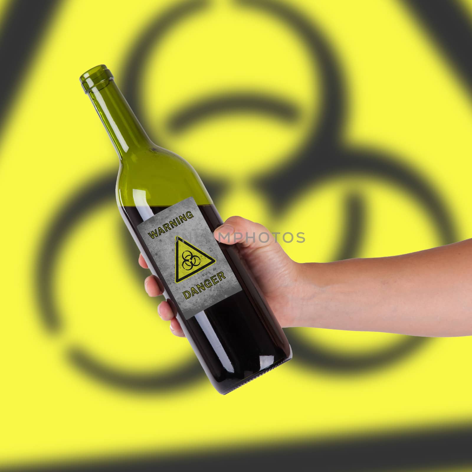 Hand holding a bottle with a warning, biohazard