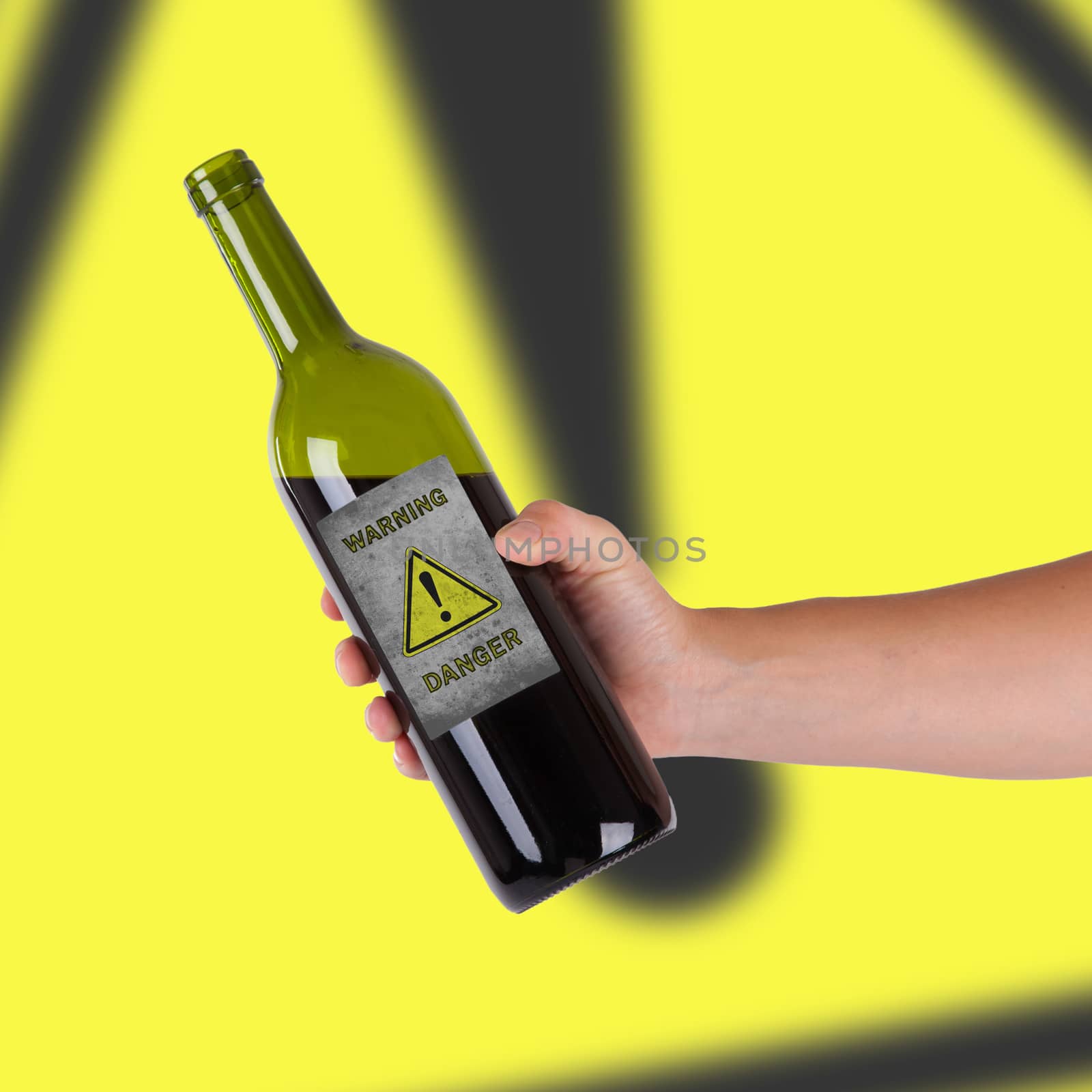 Hand holding a bottle with a warning, danger