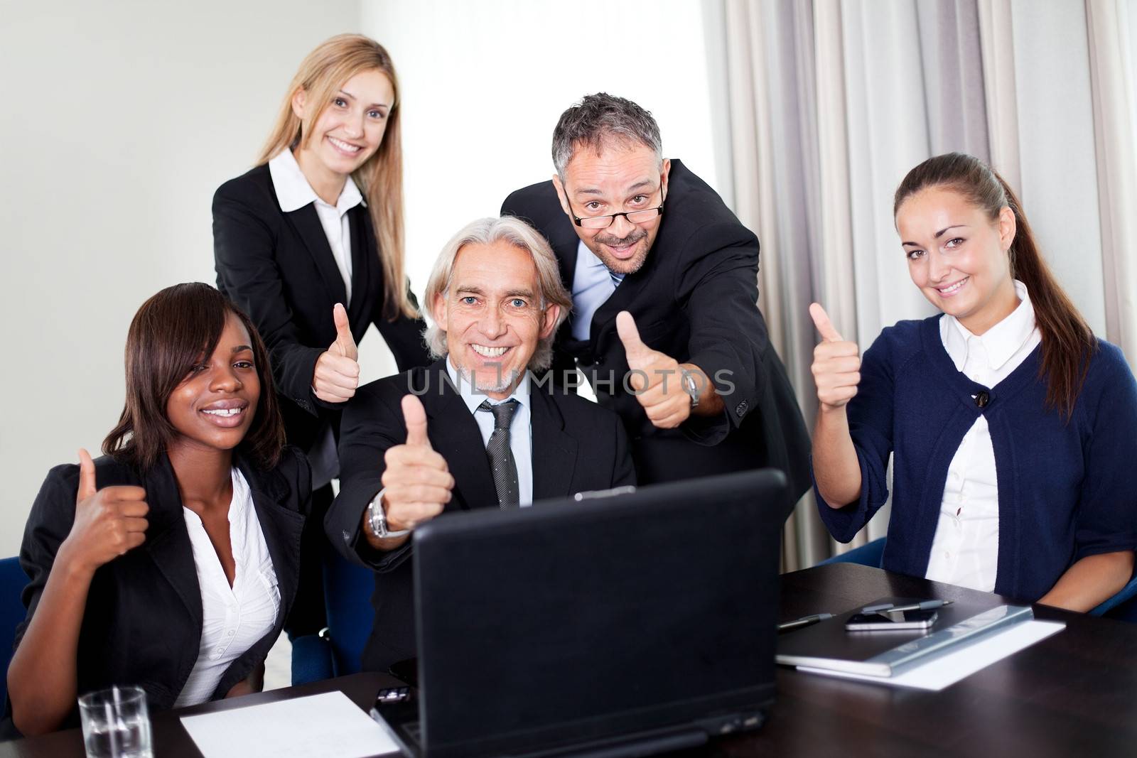Portrait of a group of mature entrepreneur in meeing at the office with laptop - Showing thumbs up