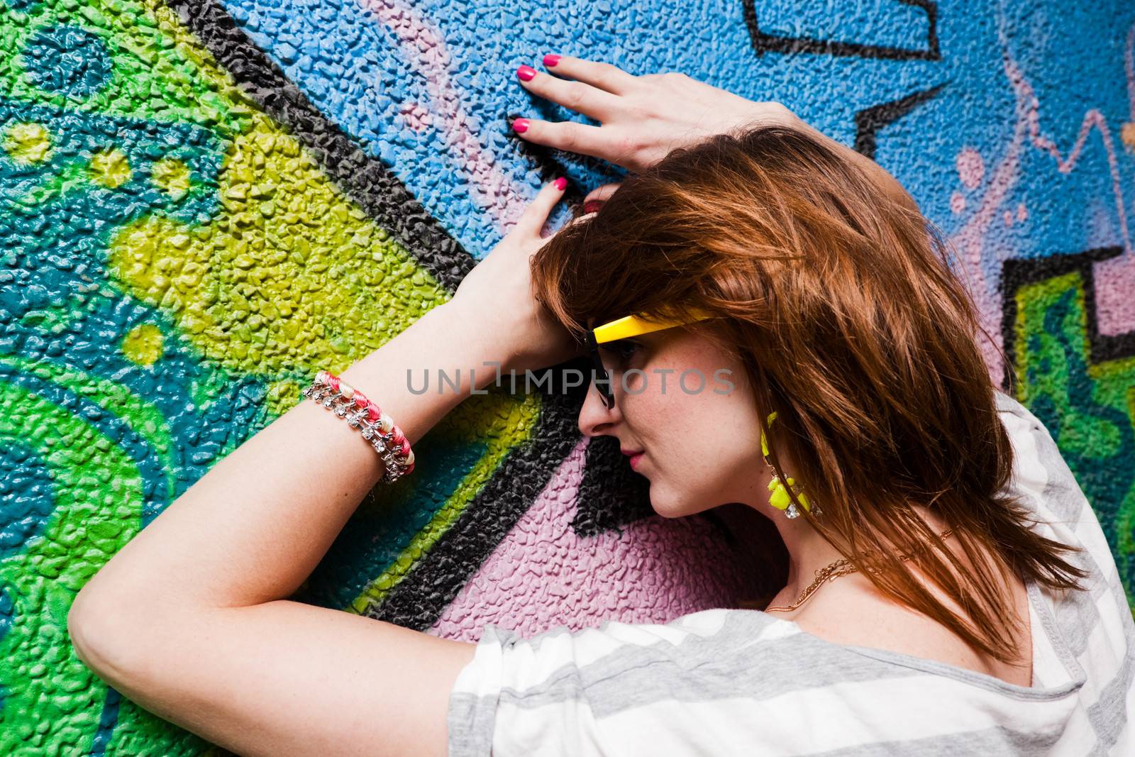 Stylish fashionable girl portrait against colorful graffiti wall. Fashion, trends, subculture.