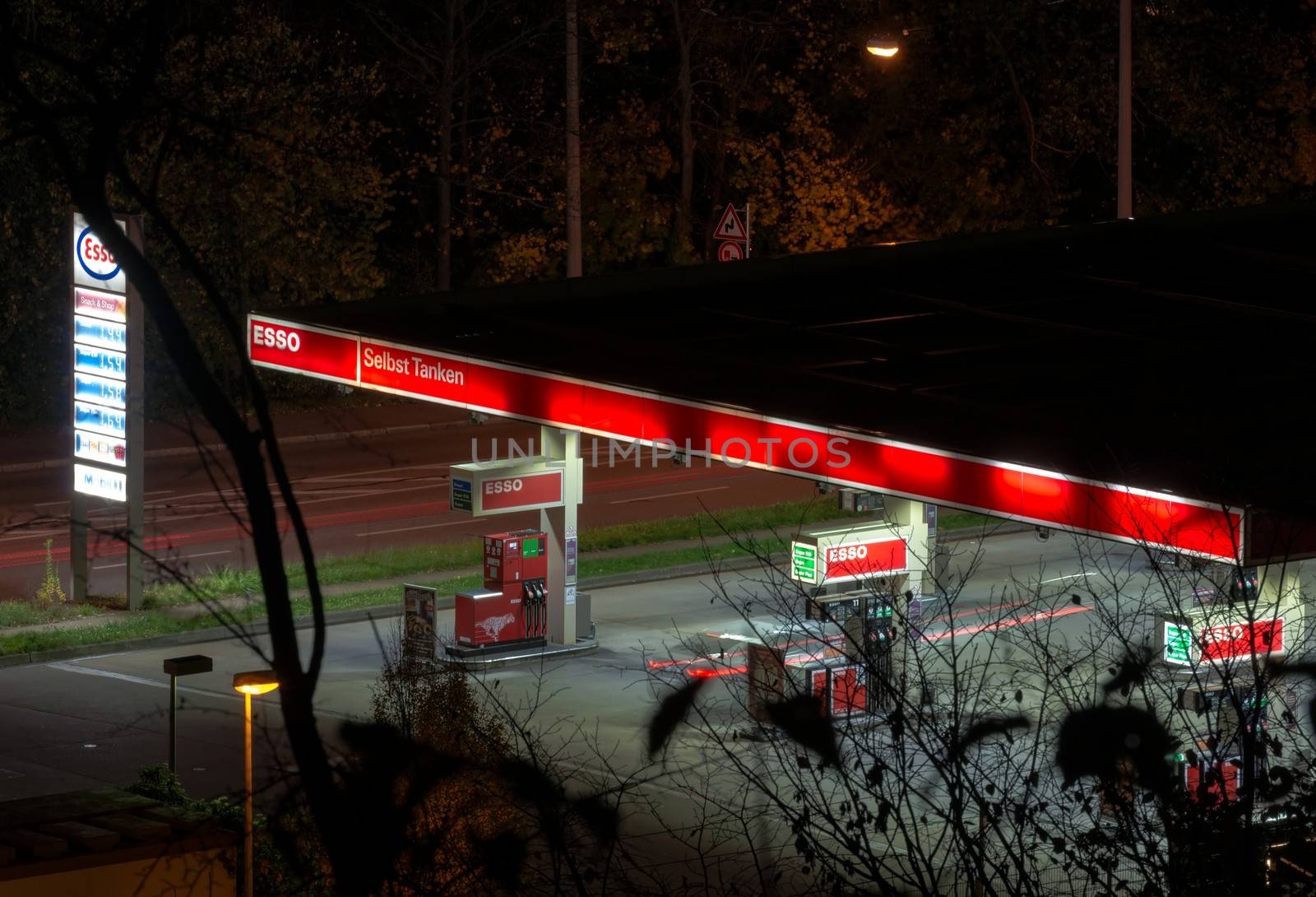 STUTTGART, GERMANY - NOVEMBER 9, 2013: Blurred traces of car leaving a petrol station at night as seen through the woods from above on November 9, 2013 in Stuttgart, Germany.