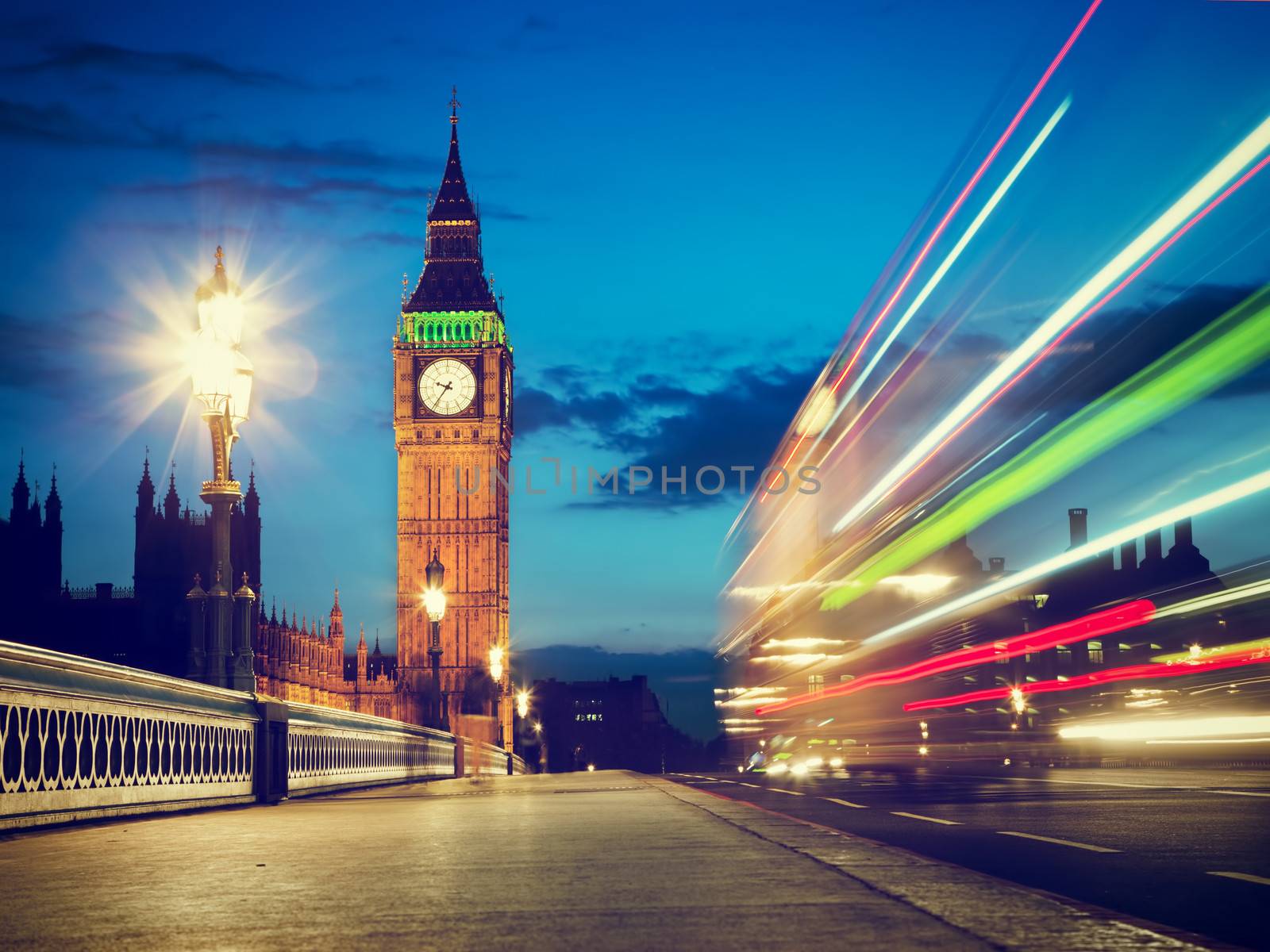 London, the UK. Red bus in motion and Big Ben, the Palace of Westminster at night. The icons of England