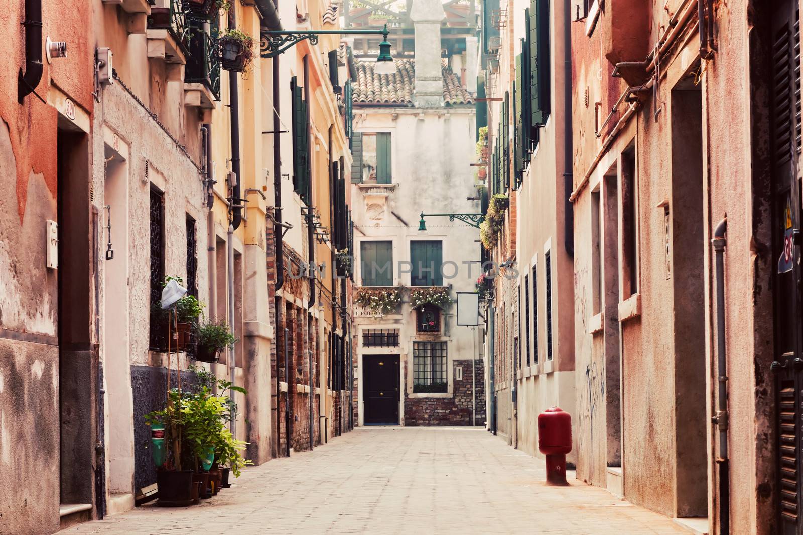 A narrow, old street in Venice, Italy. Venetian historical architecture,