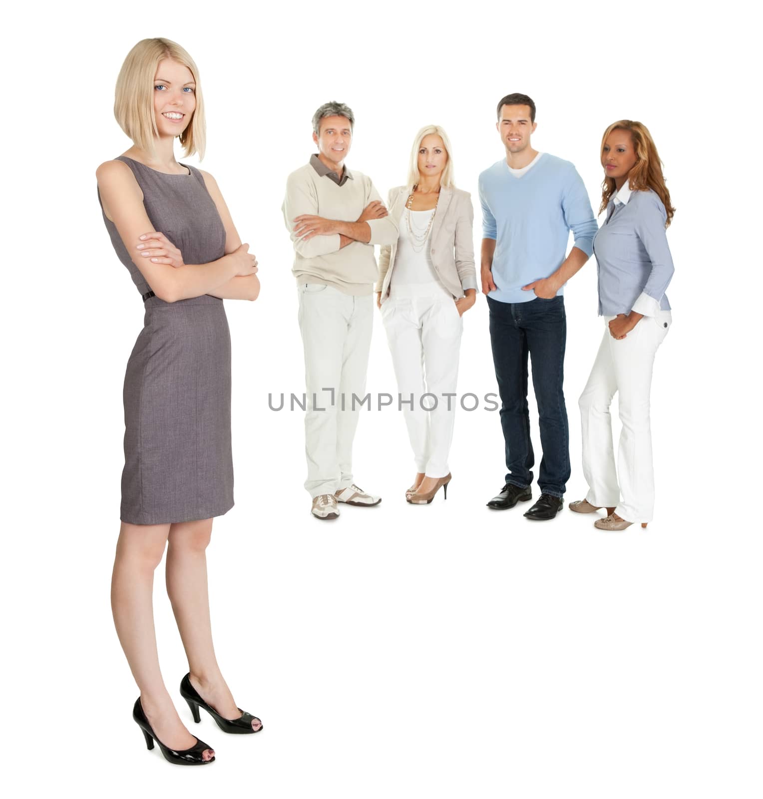 Pretty business woman standing with colleagues at the back on white