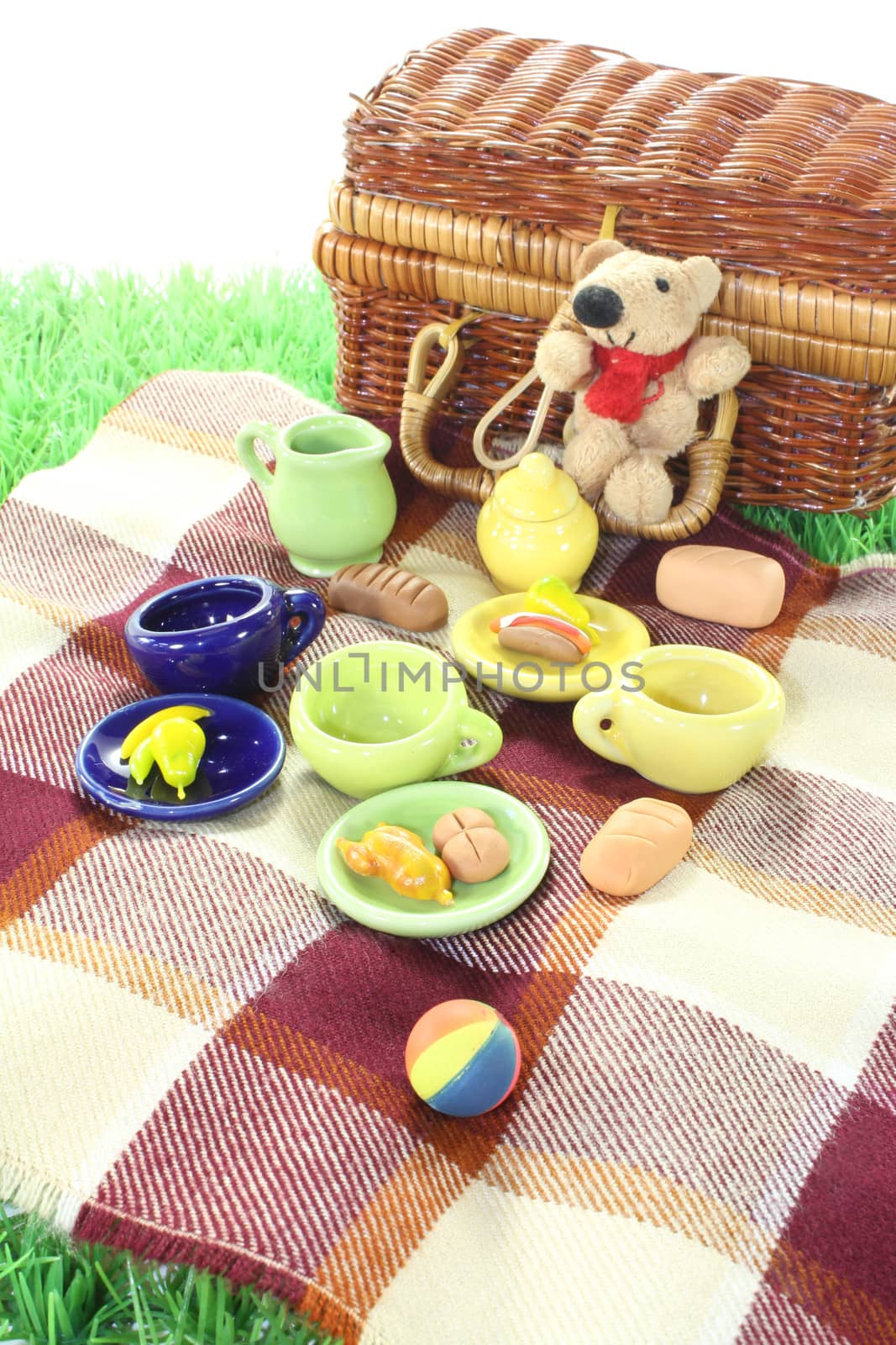 Picnic with family, ball, basket, blanket and dishes on a light background
