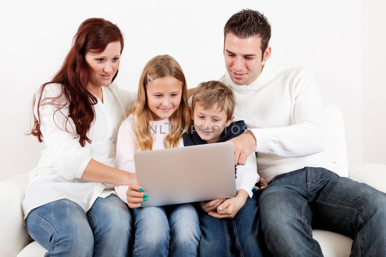 Happy family using laptop at home by AndreyPopov