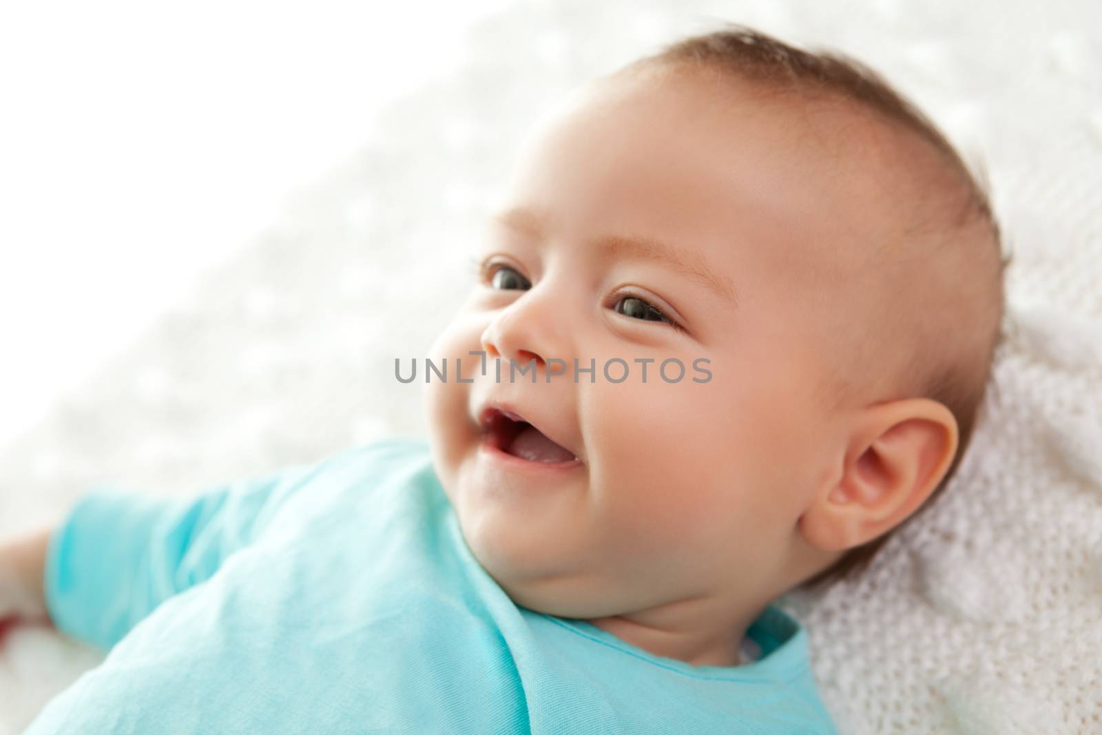 Closeup of a cute little baby smiling while lying down