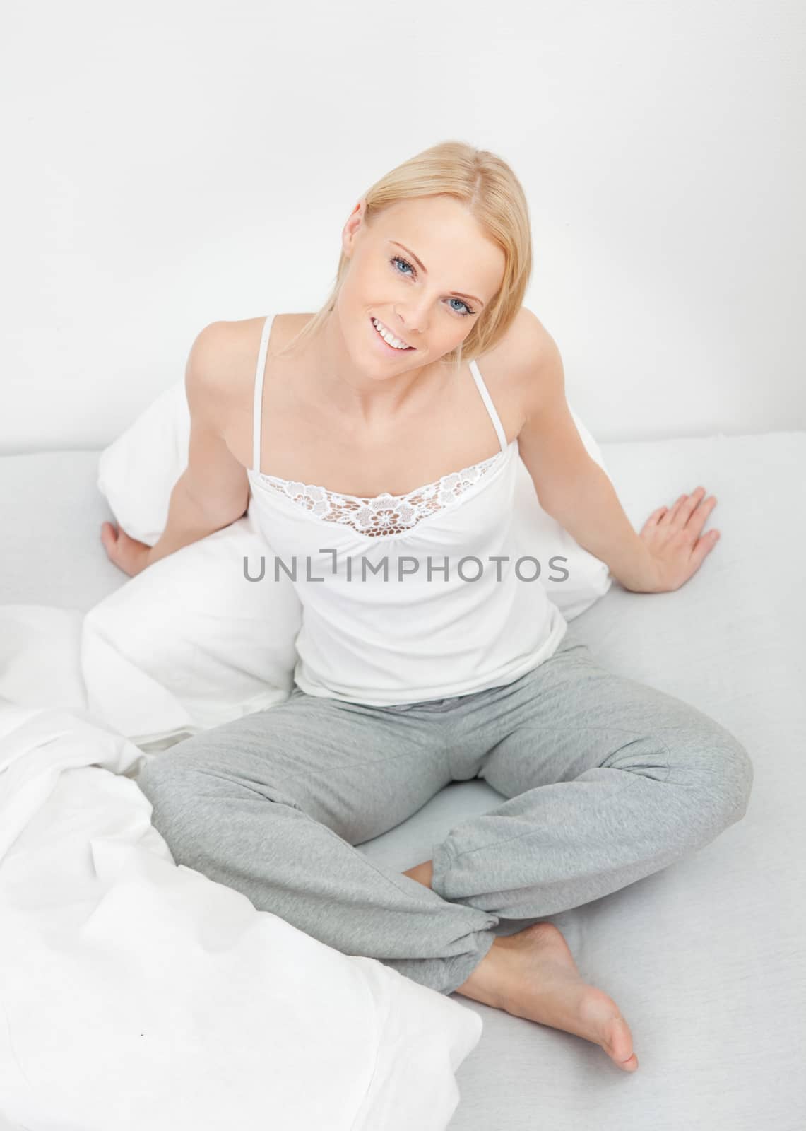 Young happy smiling woman waking up by AndreyPopov