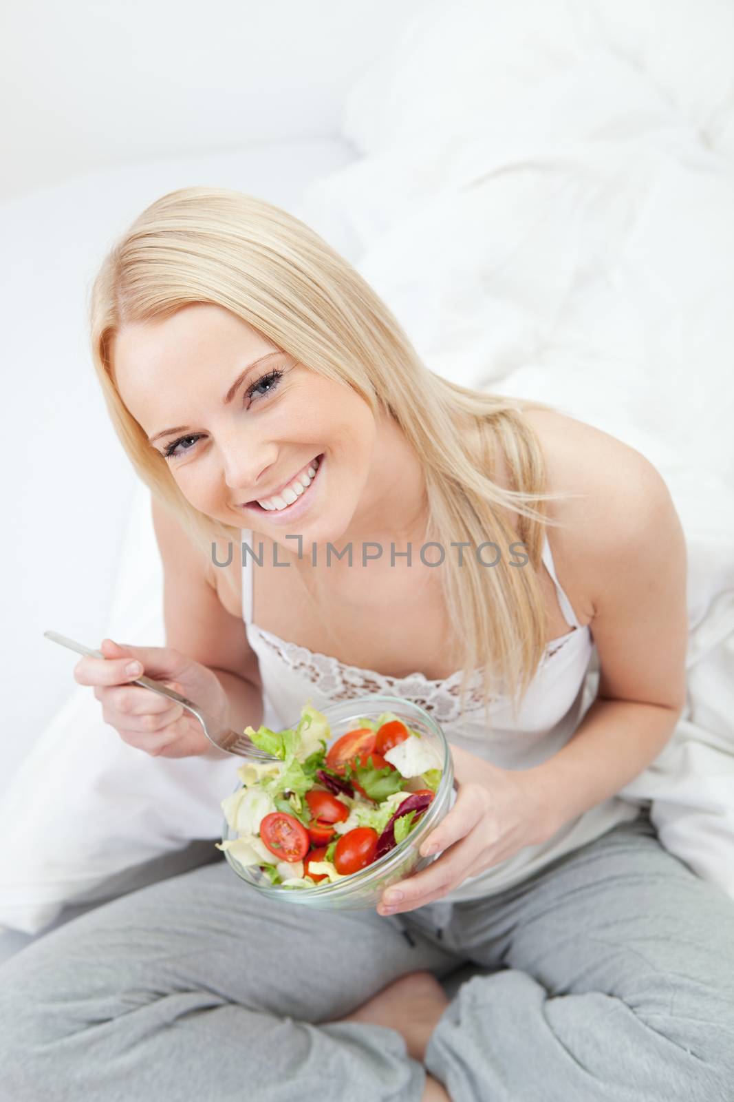 Beautiful woman eating green salad by AndreyPopov