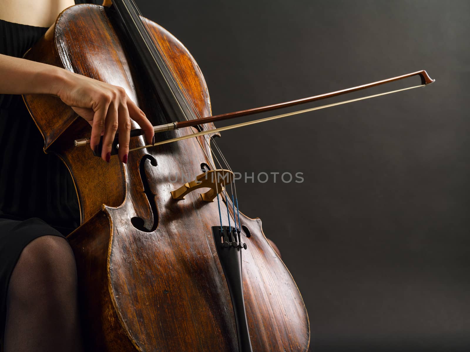 Photo of an unrecognizable female musician playing a cello.
