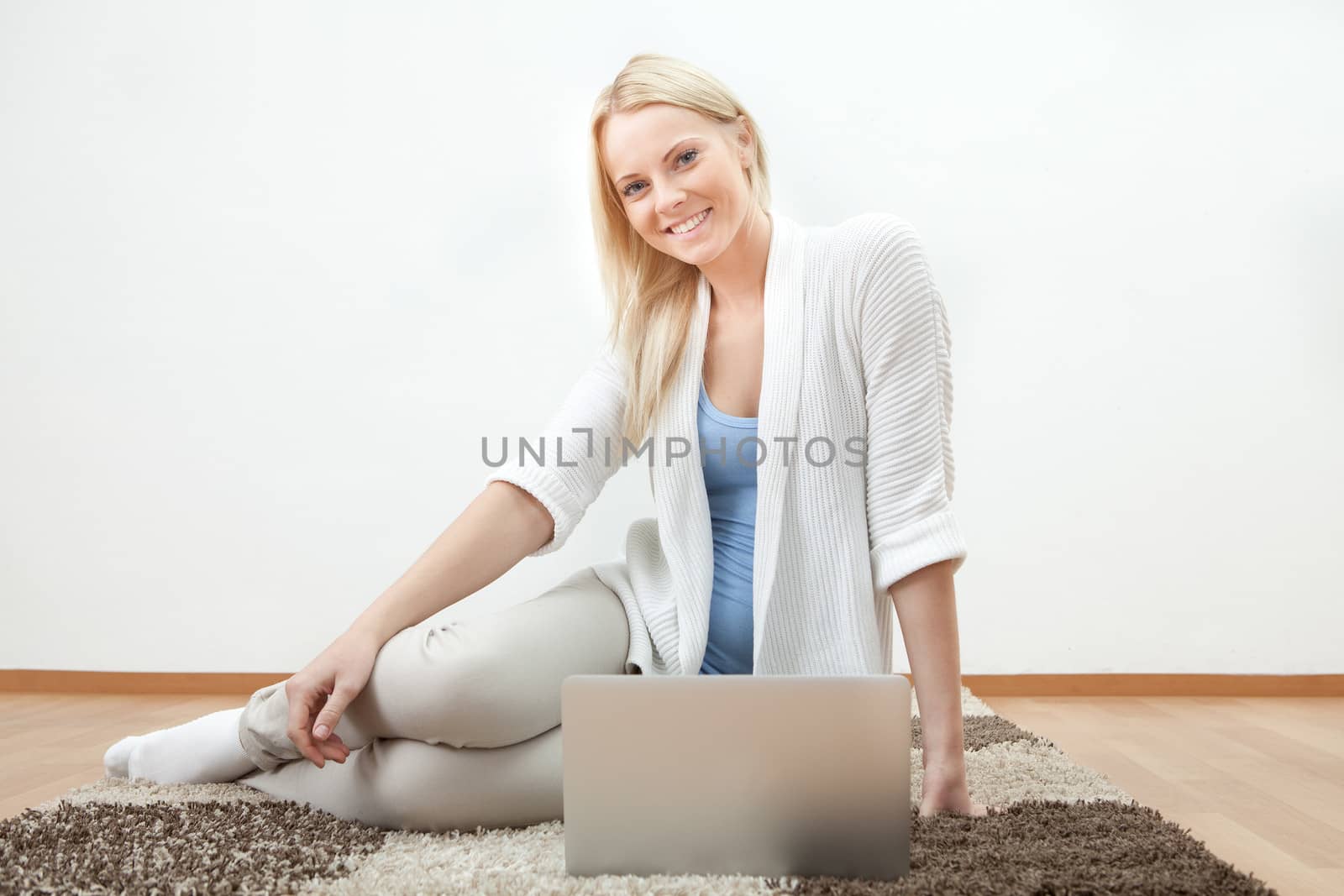 Beautiful woman working on computer sitting on floor