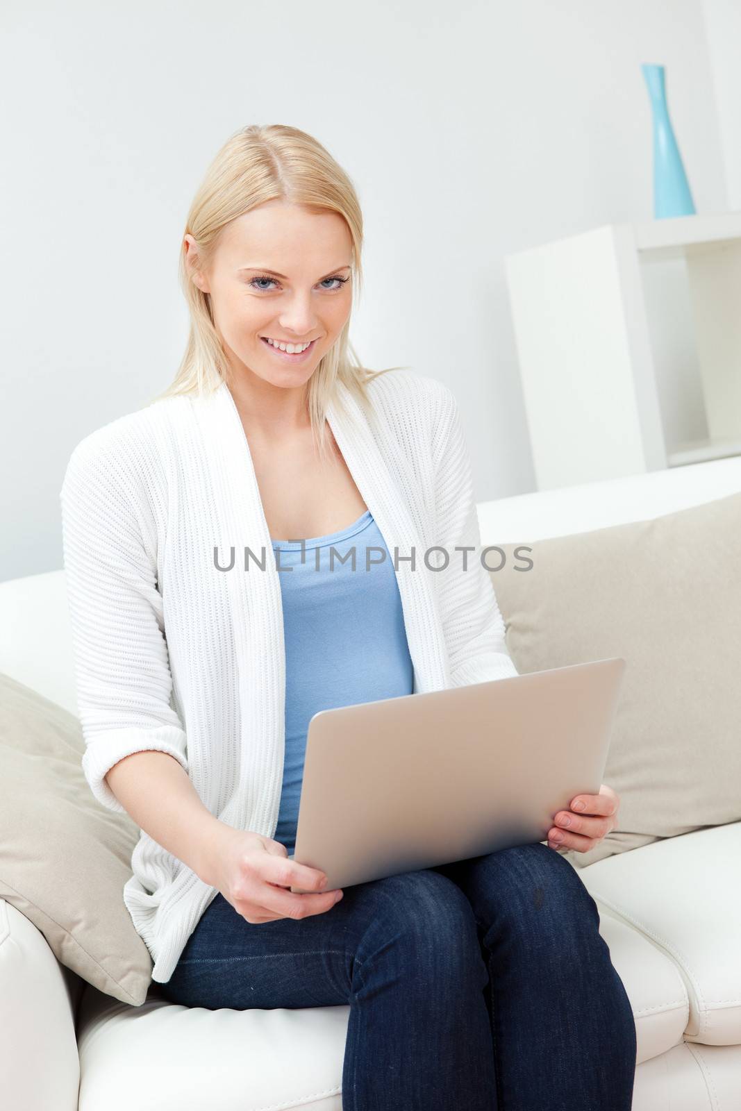 Beautiful woman shopping online with laptop sitting in sofa