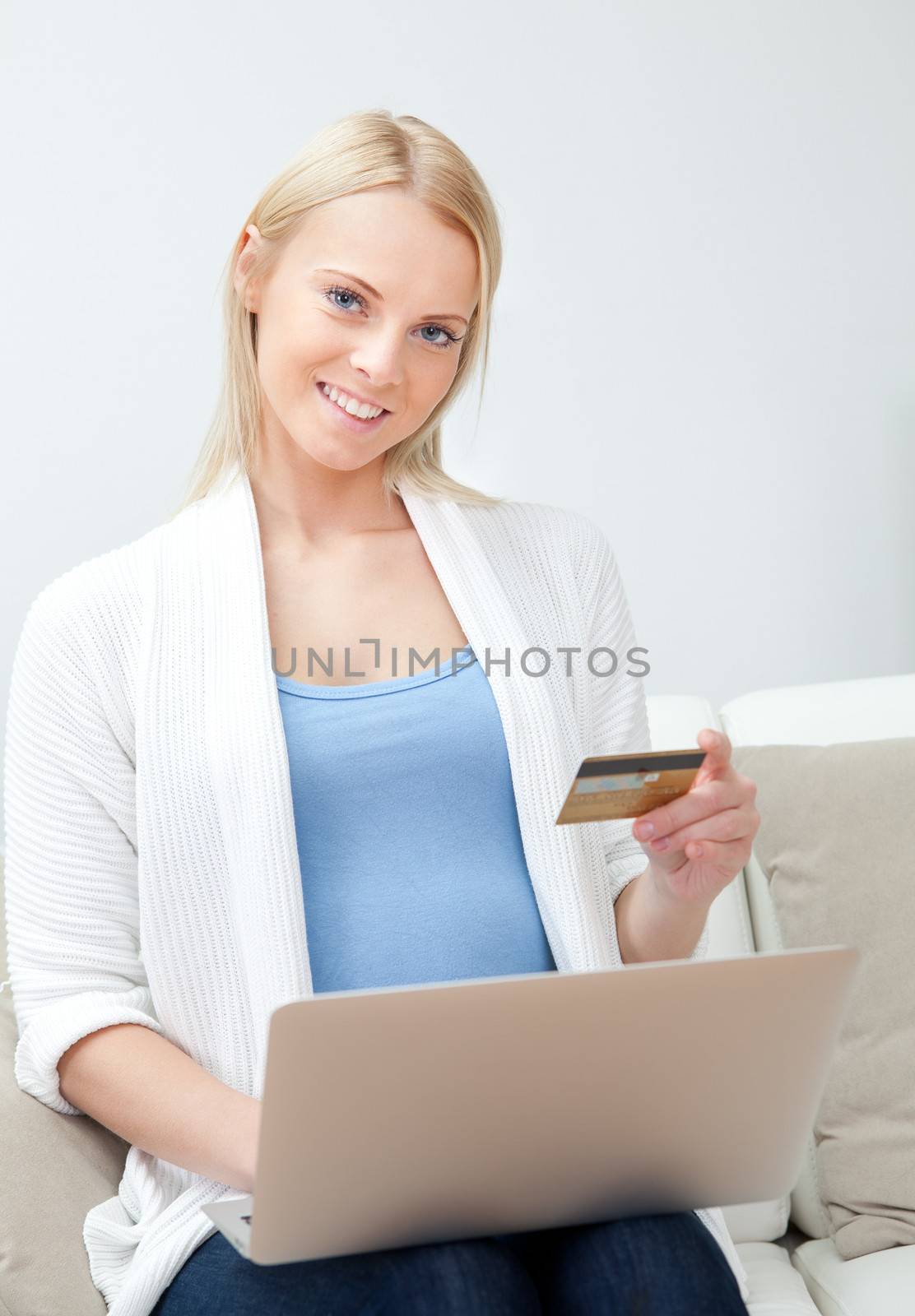 Beautiful woman shopping online with laptop sitting in sofa