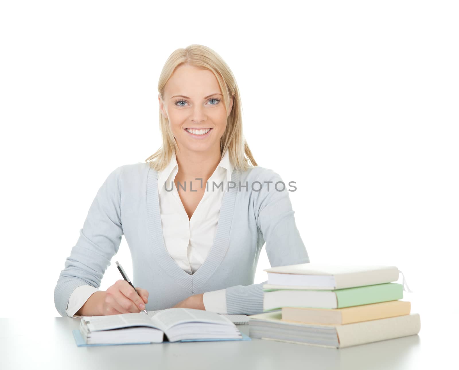 Beautiful student girl doing homework at the desk. Isolated on white