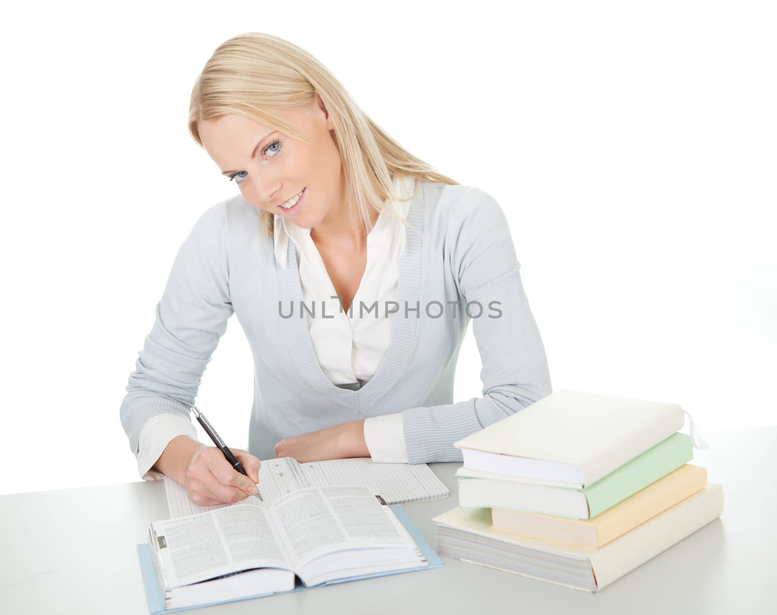 Beautiful student girl doing homework at the desk. Isolated on white