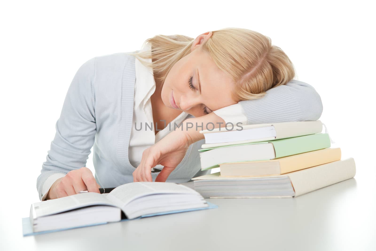 Beautiful student girl tired from doing homework at the desk. Isolated on white