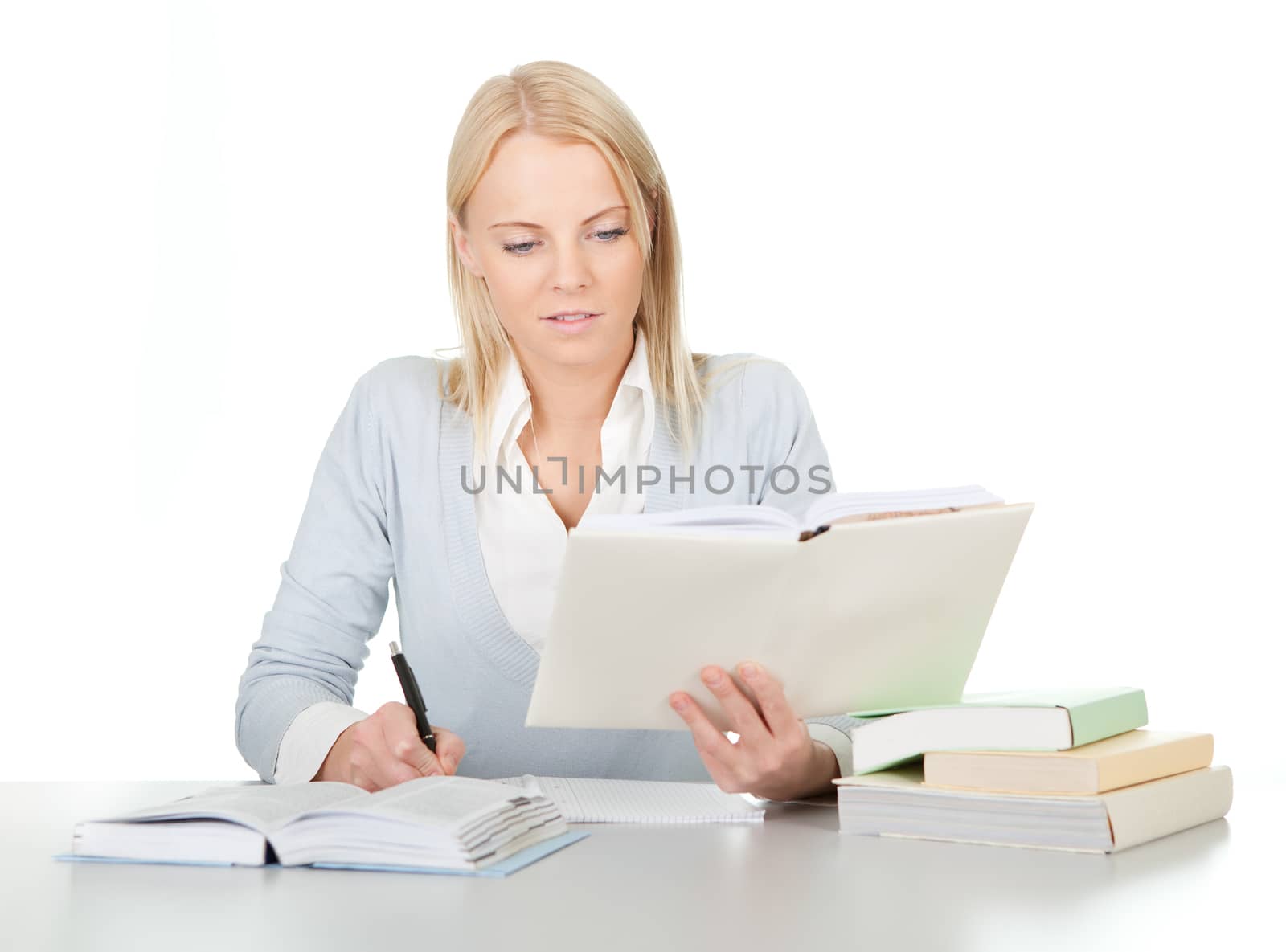 Beautiful student girl doing homework at the desk. Isolated on white